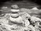 Pink summer glasses and stone pyramid on sea shore