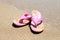 Pink summer slippers on the beach