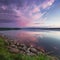 Pink sunset on the lake. Evening blue sky reflected in the water. Camping near the lake.