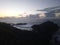 Pink sunset on the ocean. Black volcanic rocks, stones, water. Nice sky with clouds