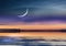 Pink sunset  on pier at sea on horizin promenade with blurred night light cloudy dramatic  blue sky and full big moon on starry sk