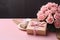 Pink table hosts Mother\\\'s Day: Rose, kraft gift box in chic arrangement.