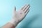 Pink tablet on medic hand with white latex gloves on a blue background. Medical concept.