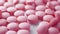 Pink tablet pills neatly arranged on a white background, symbolizing medical care and well-being, Ai Generated