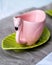 Pink tea mug on a green saucer