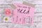 Pink tear-off stub note with text `Take what you need` and words `Love, Freedom, Hope, Courage` and `Strength` onwooden background