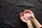 Pink tender peony in the hands of a girl. Black rumpled background. Beautiful layout of flowers