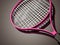 Pink tennis racket rendered on dark