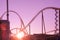 In pink tones, sunset or dawn, silhouettes of roller coasters. Background, texture