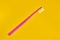 Pink toothbrush on yellow background for oral hygiene to clean teeth, gums and tongue