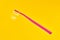 Pink toothbrush on yellow background for oral hygiene to clean teeth, gums and tongue