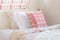 Pink triangle pattern pillow setting on bed at the corner of sweet color style bedroom