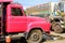 Pink truck parking with another truck