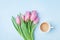 Pink tulip flowers and fresh coffee on pastel background top view. Beautiful spring breakfast on Mothers or Womans day. Flat lay.