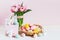 Pink tulips, easter bunnies with colorful eggs in basket