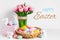 Pink tulips, easter bunnies with colorful eggs in basket, Easter concept