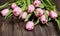 Pink tulips on old weathered wooden texture. Floral background.