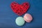 Pink and turquoise cookies, macaroni and red heart on a blue background. Close-up.