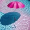 pink umbrellis floating in pool of water with shadow on the ground and a