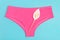 Pink underpants and flower on blue background, close up. Concept Keep your vagina healthy and happy. Top view Flat lay