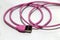 Pink used USB plug with cable on the white background.