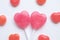 Pink Valentine`s day heart shape lollipop small red candy in cute pattern on empty white paper background. love concept. top view.