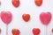 Pink Valentine`s day heart shape lollipop small red candy in cute pattern on empty white paper background. love concept. top view.