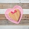 Pink Valentines Day Heart made of raw wood with a bow and doily, all on rustic shiplap boards background.  It`s a square with an