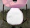 Pink and vintage retro style seat with metal and black supports.