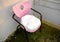 Pink and vintage retro style seat with metal and black supports.