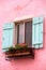 Pink wall of a house with blue window in La Provence Village. Co