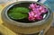 Pink water lilies in stone bowl with water and leaf