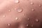 Pink waterproof fabric with water drops as background, closeup