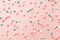 Pink,  white and blue  star shaped sprinkles on light pink background. Colourful edible cake decoration on pink background