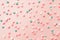 Pink,  white and blue  star shaped sprinkles on light pink background. Colourful edible cake decoration on pink background