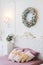 Pink and white Christmas decor in the classic bedroom, pillows on the bed and a wreat