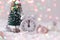 Pink and White glass Christmas balls with an alarm clock on a snowflake background, toned, lights