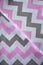 Pink, white and grey chevron pattern fabric sample. Fabric background