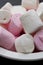 Pink and white marshmallows in white bowl
