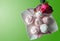Pink and white marshmallows on a white plate with butterflies, isolated rose on a green background