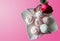 Pink and white marshmallows on a white plate with butterflies, isolated rose on pink background