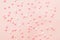 Pink and white star shaped sprinkles on light pink background. Colourful edible cake decoration on pink background