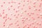 Pink and white star shaped sprinkles on light pink background. Colourful edible cake decoration on pink background