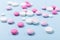 Pink and white tablets on blue background Heap of assorted various medicine tablets