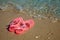 Pink Women`s JELLY SANDALS on a sea shore. LADIES FLAT JELLIES SUMMER BEACH SHOES.