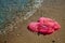 Pink Women`s JELLY SANDALS on a sea shore. LADIES FLAT JELLIES SUMMER BEACH SHOES.