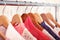 Pink womens clothes on hangers on rack in fashion store. closet