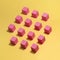 Pink wooden blocks on a yellow background. Modern conceptual art.