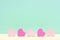 Pink wooden hearts against a turquoise background