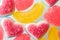 Pink and yellow chewy candies in powdered sugar, gelatin sweets close-up